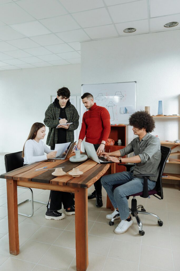 Young professionals brainstorm in a well-lit office setting, engaging in teamwork and discussion.